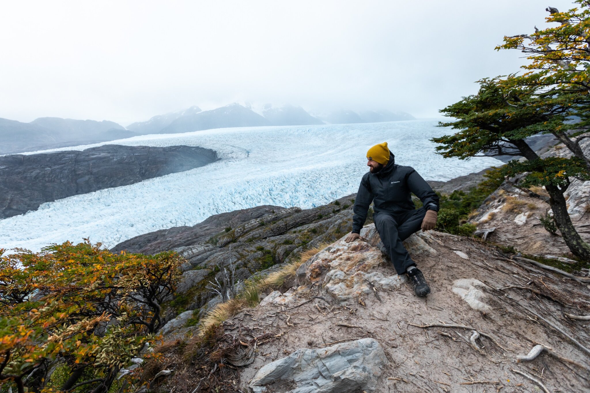 Hombre senderista descansa frente al Glaciar Paine en Chile